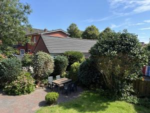a garden with a table and chairs and bushes at Führs in Borkum