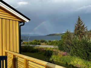 a balcony with a view of a lake from a house at Senja Peak Panorama in Straumstad