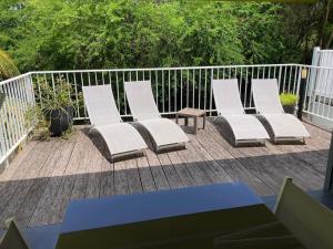 a group of white chairs sitting on a deck at Villa Shenandoah in Sainte-Anne
