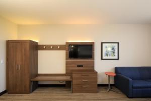 a living room with a tv and a blue couch at Holiday Inn Express - Grand Island by IHG in Niagara Falls