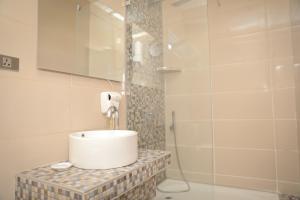 un bagno con lavandino e doccia di Hotel Martini Kvariati a Kvariati