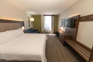 a hotel room with a bed and a flat screen tv at Holiday Inn Express - Grand Island by IHG in Niagara Falls