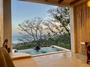 a room with a pool with a view of the ocean at Casa Gaya in San Pedro Pochutla