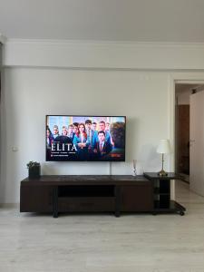 einen Flachbild-TV an der Wand im Wohnzimmer in der Unterkunft Cozi place in Voluntari