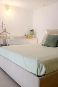 a large white bed in a bedroom with a dog on it at Il Nido di Nenna Apartment in Meta