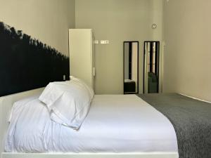 a bed with white sheets and pillows in a room at PlazaMayorSuites in Madrid