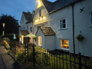 a white building with a fence in front of it at The Black Horse Inn in Dursley