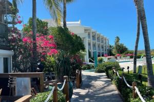 a resort with pink flowers and palm trees at Luxury Beachfront Apartments Grace Bay Beach in The Bight Settlements