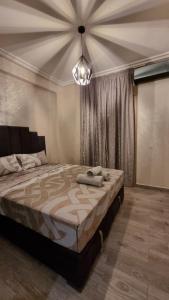 a bedroom with a large bed and a chandelier at Appartement Mima Marrakech Proche centre ville, cosy et spacieux in Marrakech +9 photos