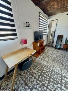 a room with a wooden table and a desk at Casa Hostal La Esperanza de Don Alfonso in León +30 photos