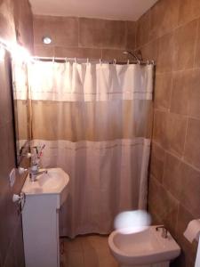 a bathroom with a sink and a toilet and a shower curtain at La casa de Bada in Miramar