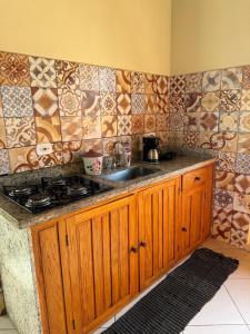 Una cocina con fregadero y encimera con azulejos. en Casa Campos, en Paraty