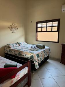 Un dormitorio con dos camas y una ventana. en Casa Campos, en Paraty
