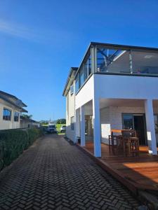 a house with a brick road next to a building at Whangamata Harbour Haven in Whangamata