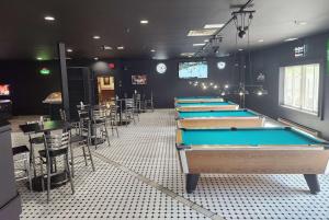 a row of billiard tables in a room with tables and chairs at Days Inn by Wyndham Renfrew Conference Centre in Renfrew