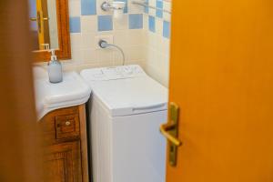 a bathroom with a sink and a washing machine at ALBACHIARA by CefaLux in Cefalù +49 photos