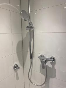 a shower with a shower head in a bathroom at Downtown Residence Düsseldorf in Düsseldorf