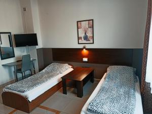 a hotel room with two beds and a desk at Arkadia Noclegi in Łuków