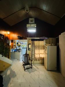 a kitchen with a chair and a refrigerator at Hidden Resort Abbottabad in Abbottabad