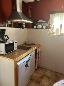 a kitchen with a microwave and a sink at El Cercón de Candelo in Magacela