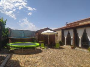 a patio with a large green table and chairs at El Cercón de Candelo in Magacela