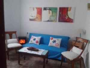 a living room with a blue couch and two chairs at El Cercón de Candelo in Magacela