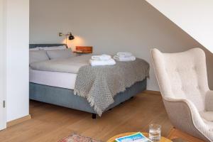 a bedroom with a bed and a chair and a table at Haus am Rebberg in Öhningen