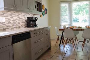 a kitchen with a counter and a table with chairs at Birdsong Bungalow in Port Dover