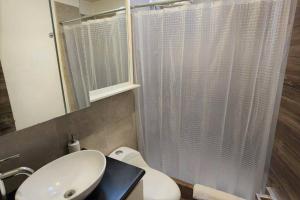 a bathroom with a sink and a toilet and a mirror at DSt4 Well stocked studio in zone 15 in Guatemala