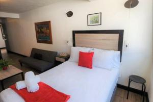 a bedroom with a large white bed with red pillows at DSt4 Well stocked studio in zone 15 in Guatemala