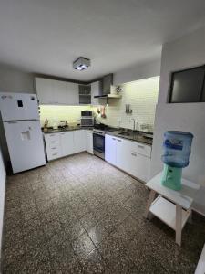 a kitchen with white cabinets and a white refrigerator at Casa centrica, cómoda y amplia in Corrientes