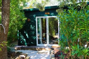 un pequeño cobertizo con una puerta en un jardín en Casa Seahorses b Cottage, en Sintra