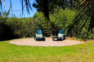 two blue chairs sitting on the sand in the grass at Casa Seahorses b Cottage in Sintra