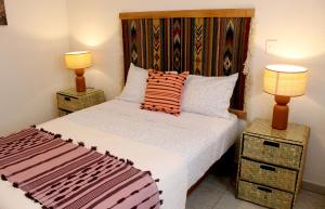 a bedroom with a large bed with two lamps at Vistas Pátzcuaro 302 in Pátzcuaro