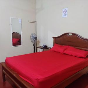 a bedroom with a large red bed with a red blanket at Hotel Eco Tours Tariquia in Bermejo