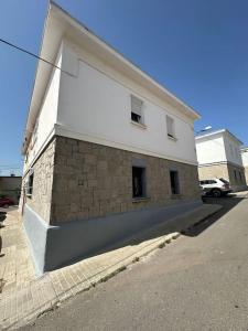 ein weißes Gebäude mit Ziegelwand neben einer Straße in der Unterkunft Apartamento Tahoní Tarifa Centro in Tarifa