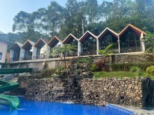 MargawinduにあるKampung Karuhan Eco Green Park Sumedangの岩壁とウォータースライダー付きのリゾート