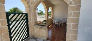 a balcony with an archway with a table and a table at MAREE SOL RESIDENCE Camere e Appartamenti in Torre San Giovanni Ugento