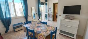 a dining room with a table and a television at MAREE SOL RESIDENCE Camere e Appartamenti in Torre San Giovanni Ugento