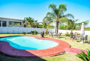 a swimming pool in a yard with a table and chairs at NKGuestHouse in Ladysmith