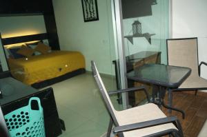 un salon avec un lit, une table et des chaises dans l'établissement Penthouse con Jacuzzi en Acapulco Diamante, à Acapulco 85 autres photos