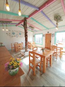 a dining room with wooden tables and chairs and a tree at Tiny houses temáticas en medio del bosque el jardín del chucao in Maullín