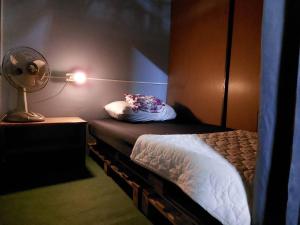 Kleines Zimmer mit einem Bett und einem Ventilator. in der Unterkunft HostelBed and Retreat Phitsanulok in Phitsanulok + 40 Fotos