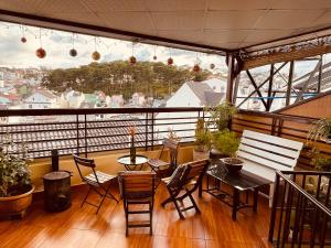 a balcony with a table and chairs and a view at BắpHouseHomestay in Da Lat