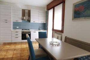 a kitchen with a table and blue and white cabinets at casa a schiera, a 150mt dal mare in Lido di Jesolo