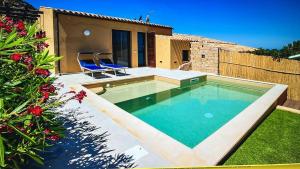 a swimming pool with two blue chairs in a backyard at Villa Vincent in Costa Paradiso