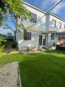 a white house with a picnic table in the yard at Scarlett Studios 3-US Embassy 7 mins drive- Lloyd Erskine Sandiford Centre & Ross university 5 mins drive-Only a 1 night reservation includes airport and embassy round trip in Bridgetown +21 photos