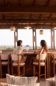 a man and a woman sitting at a table at Hotel Boutique Xiqué in Brisas de Zicatela
