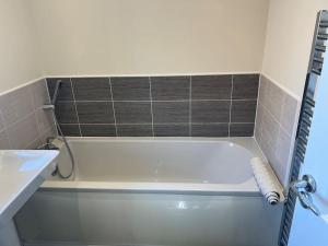 a white bath tub in a bathroom with a sink at Great Ambience 3-Bedroom for Groups & Contractors in Rubery