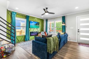 a living room with a blue couch and green walls at 4BD with BBQ & Games - Duke, NCCU and Downtown Nearby in Durham